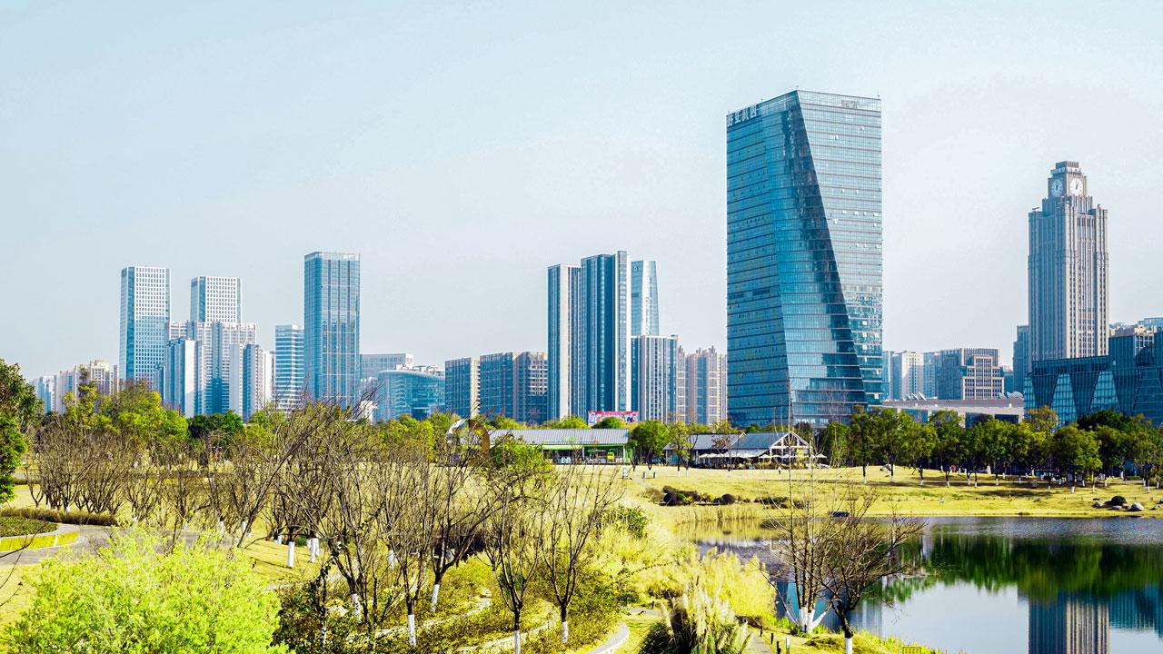 A park and waterbody with a city skyline in the background