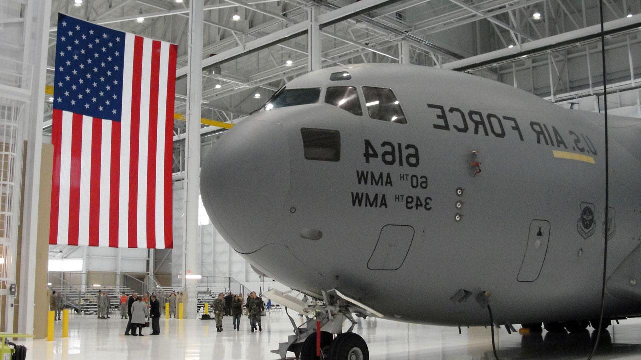 KC-10 advanced tanker and cargo aircraft in hangar with a United States flag hanging in the background